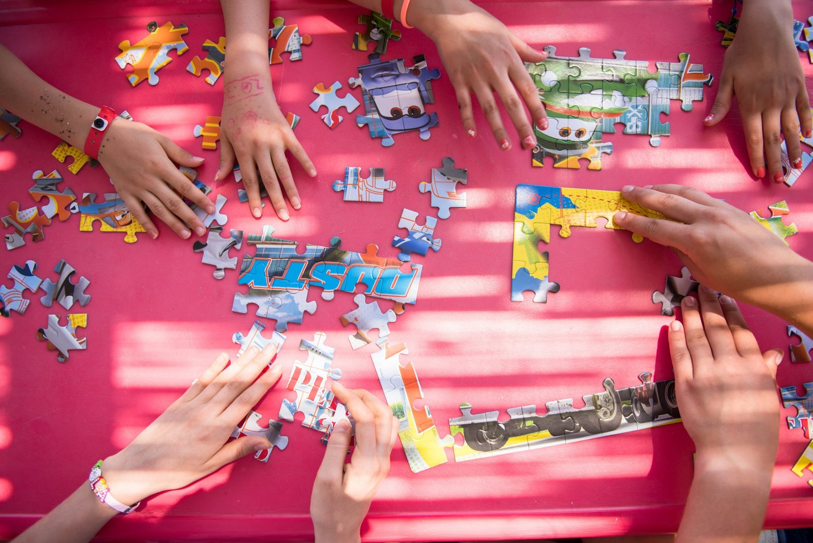 top view of kids hands playing with puzzles