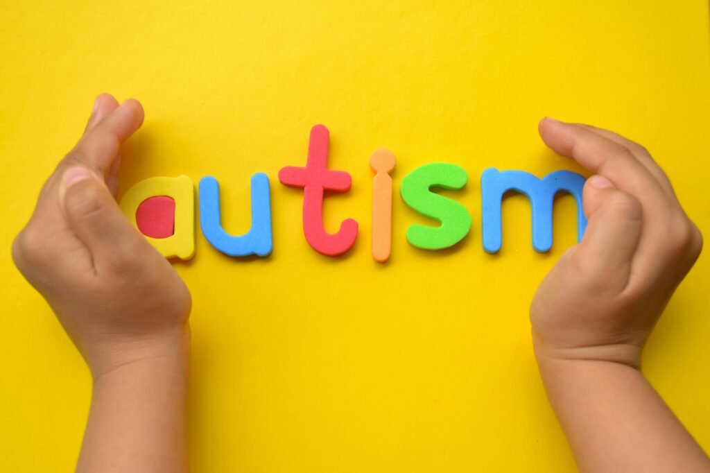 Hand of child with colorful autism letters