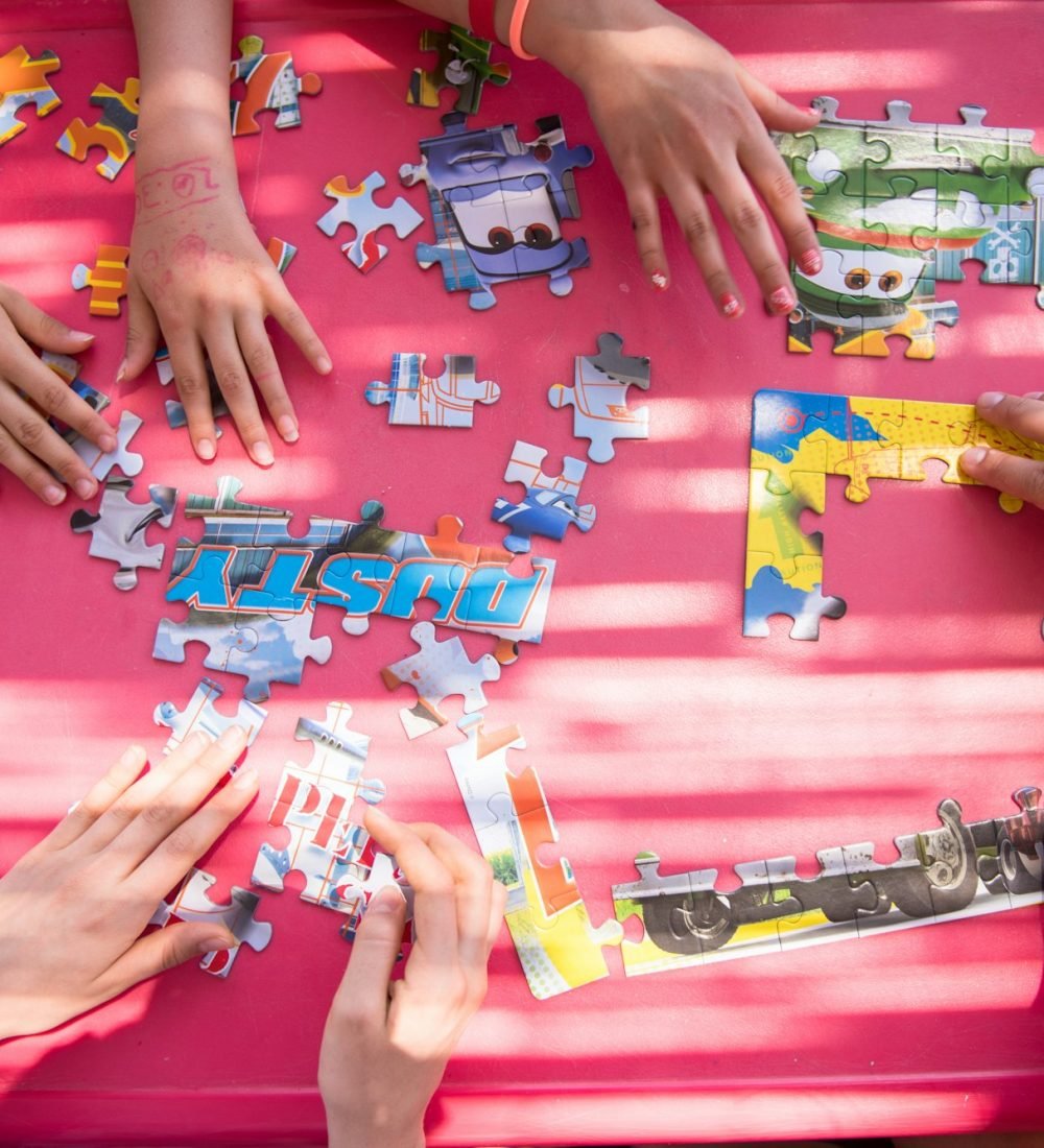 top view of kids hands playing with puzzles